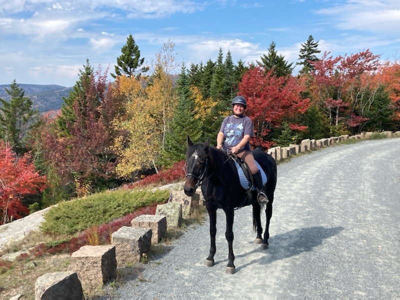 Horse book author Laura Holt-Haslam rides Soprano along Acadia&rsquo;s carriage trails.